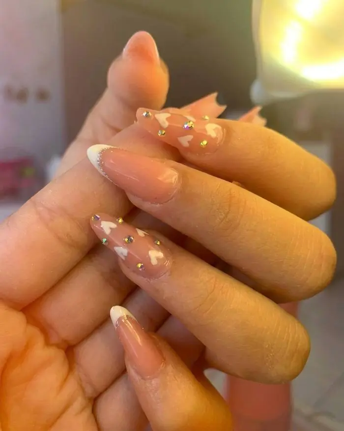 Unhas nude com corações e glitter